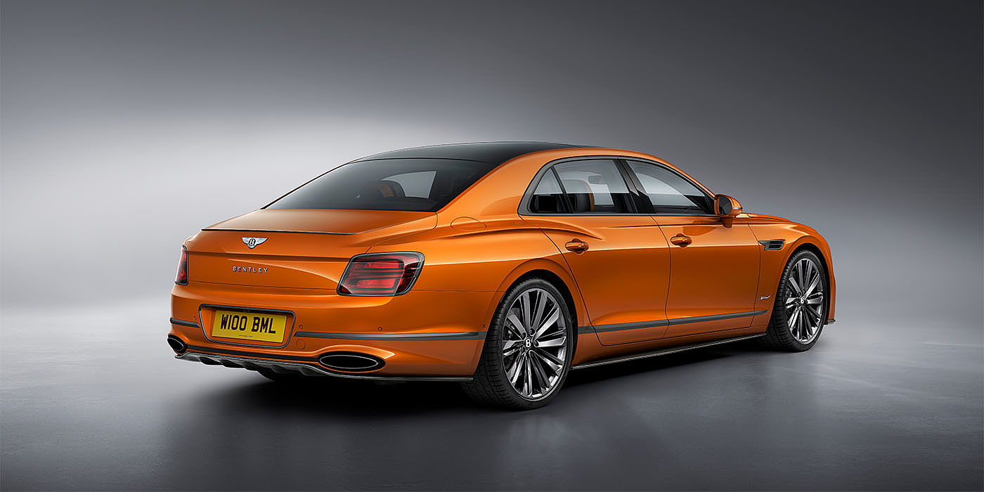 Bentley Bahrain Bentley Flying Spur Speed in Orange Flame colour rear view, featuring Bentley insignia and enhanced exhaust muffler.